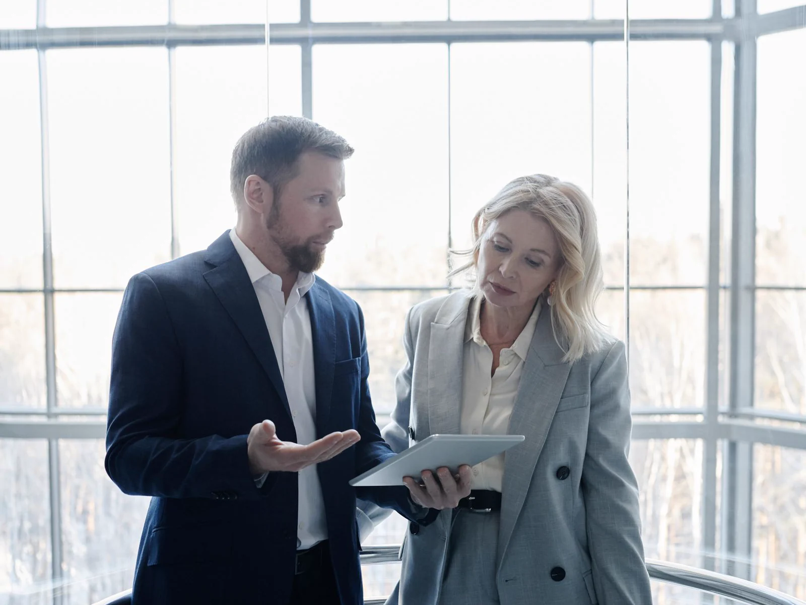 Professionals discussing property operations with a tablet inside a modern commercial building